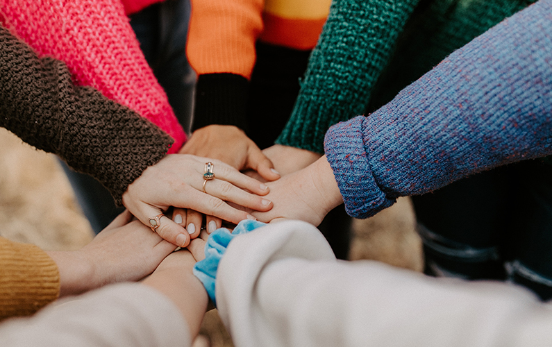 Groupe de personnes qui mettent les mains ensemble